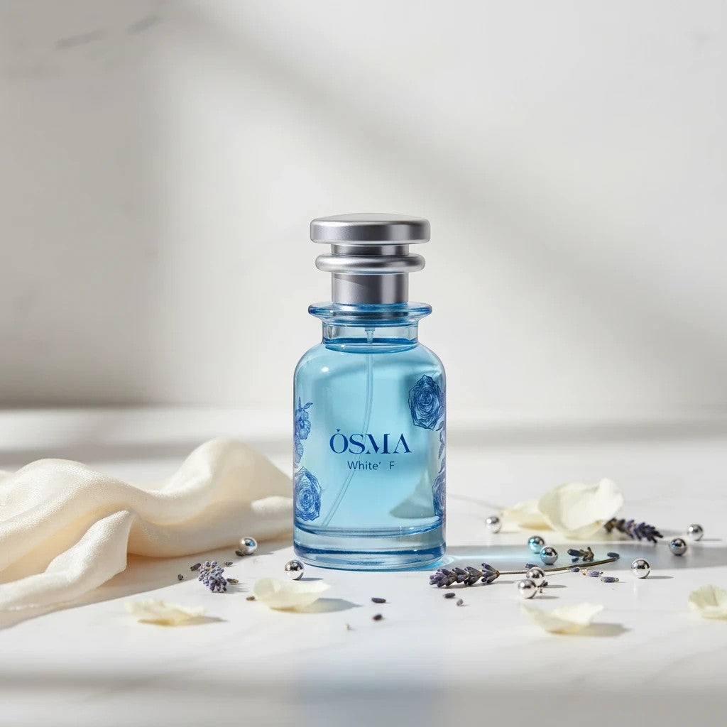 Osma White F Eau de Parfum by Osma, a sweet gourmand fragrance in a clear blue glass bottle with silver cap, featuring blue floral accents.