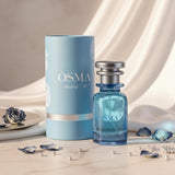 Osma Woody W Eau de Parfum 75ml bottle and cylindrical box, light blue with white floral accents. Fresh woody aromatic fragrance.