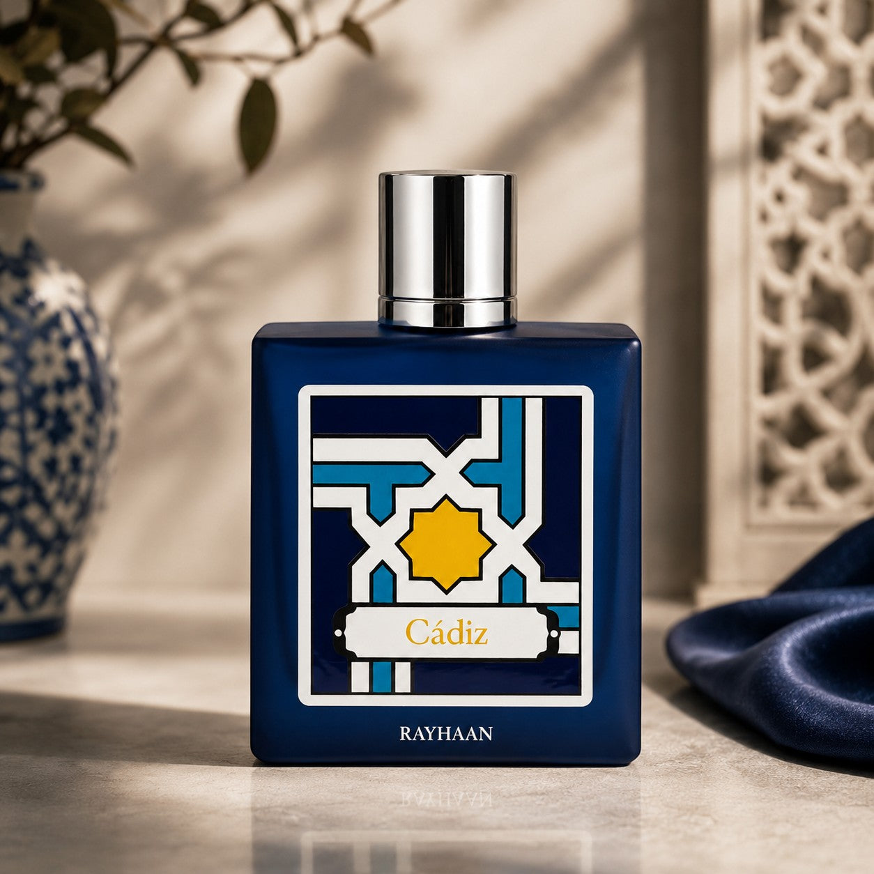Rayhaan Cadiz Eau de Parfum in a dark blue bottle with a geometric label. Unisex amber woody oriental fragrance.