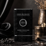 Soghaat Anfar London Nero Velours Extrait de Parfum in a black velvet-textured bottle on a dark marble surface.