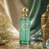 Soghaat Anfar Vague Extrait de Parfum in a green glass bottle with gold ornate cap, set against silk and lanterns.