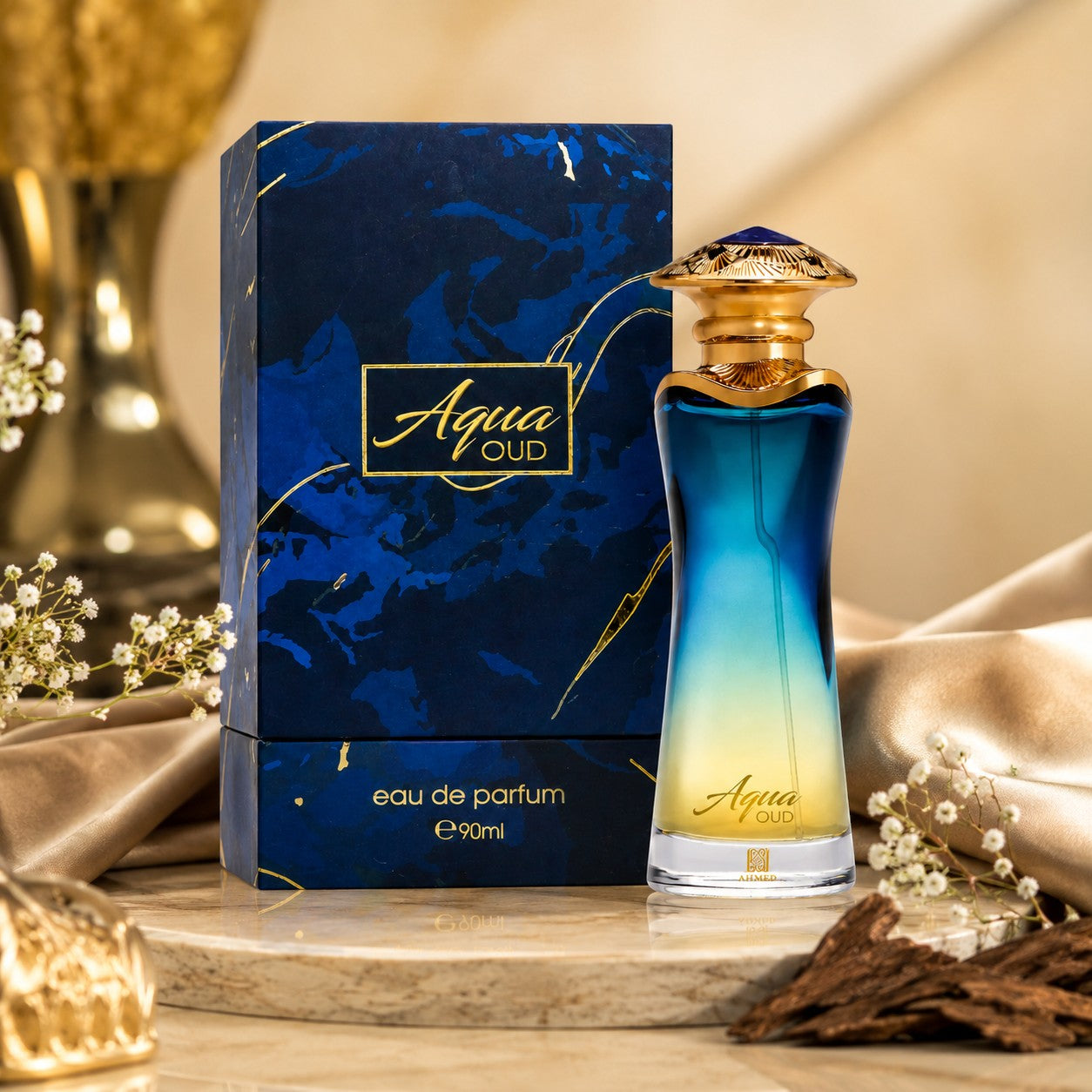 Soghaat Aqua Oud Eau de Parfum bottle and box with blue to yellow gradient glass, gold cap, and marble-effect packaging