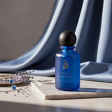 Soghaat Blue Laverne Eau de Parfum bottle with a wooden cap, featuring a blue frosted glass bottle and silver emblem.