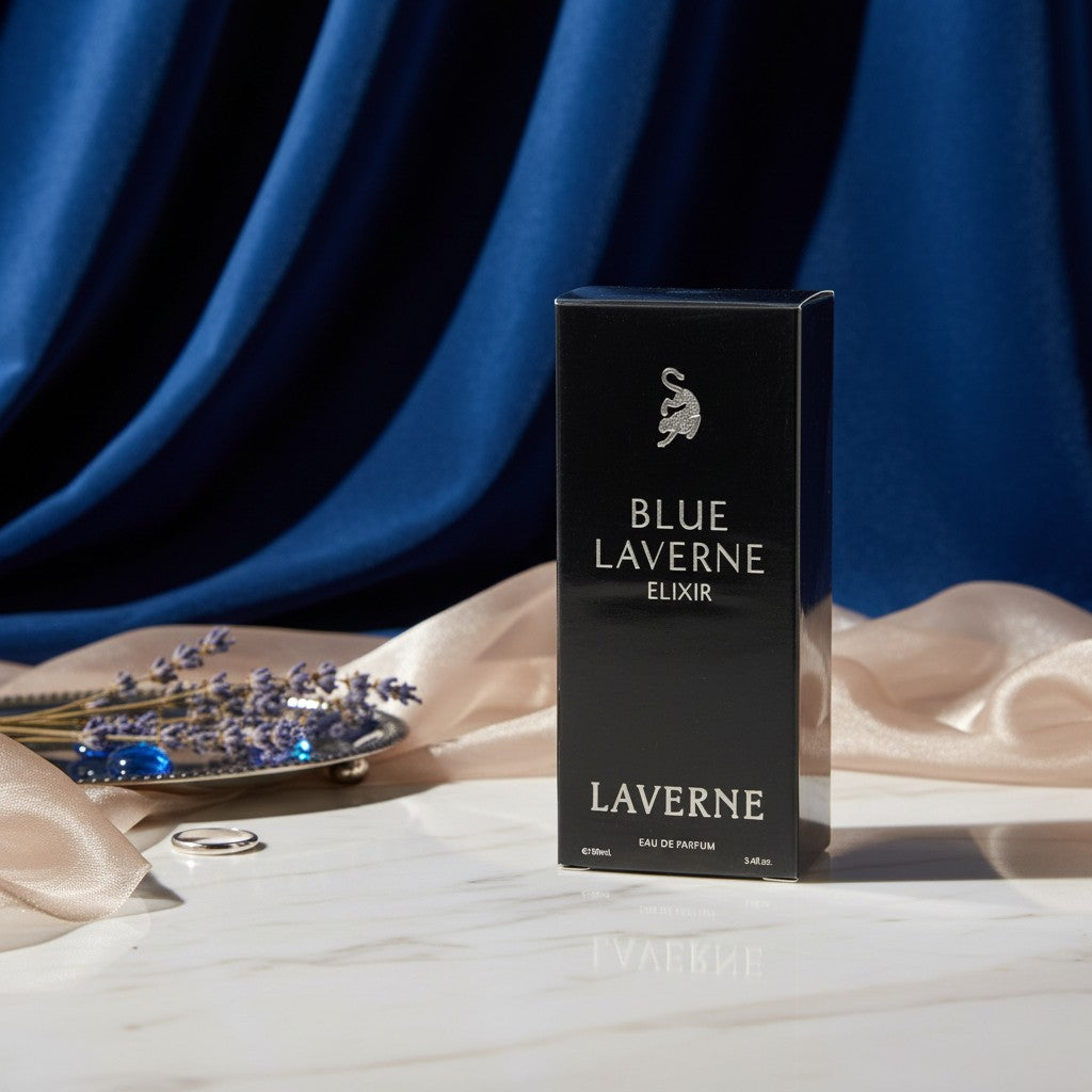 Soghaat Blue Laverne Elixir Eau de Parfum bottle on a marble surface with lavender, silk fabric, and blue backdrop.
