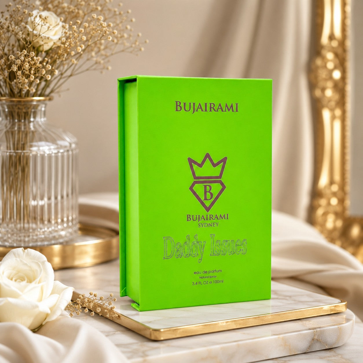 Soghaat Bujairami Daddy Issues 100ml Eau de Parfum in a vibrant lime green box on a marble tray with white roses.