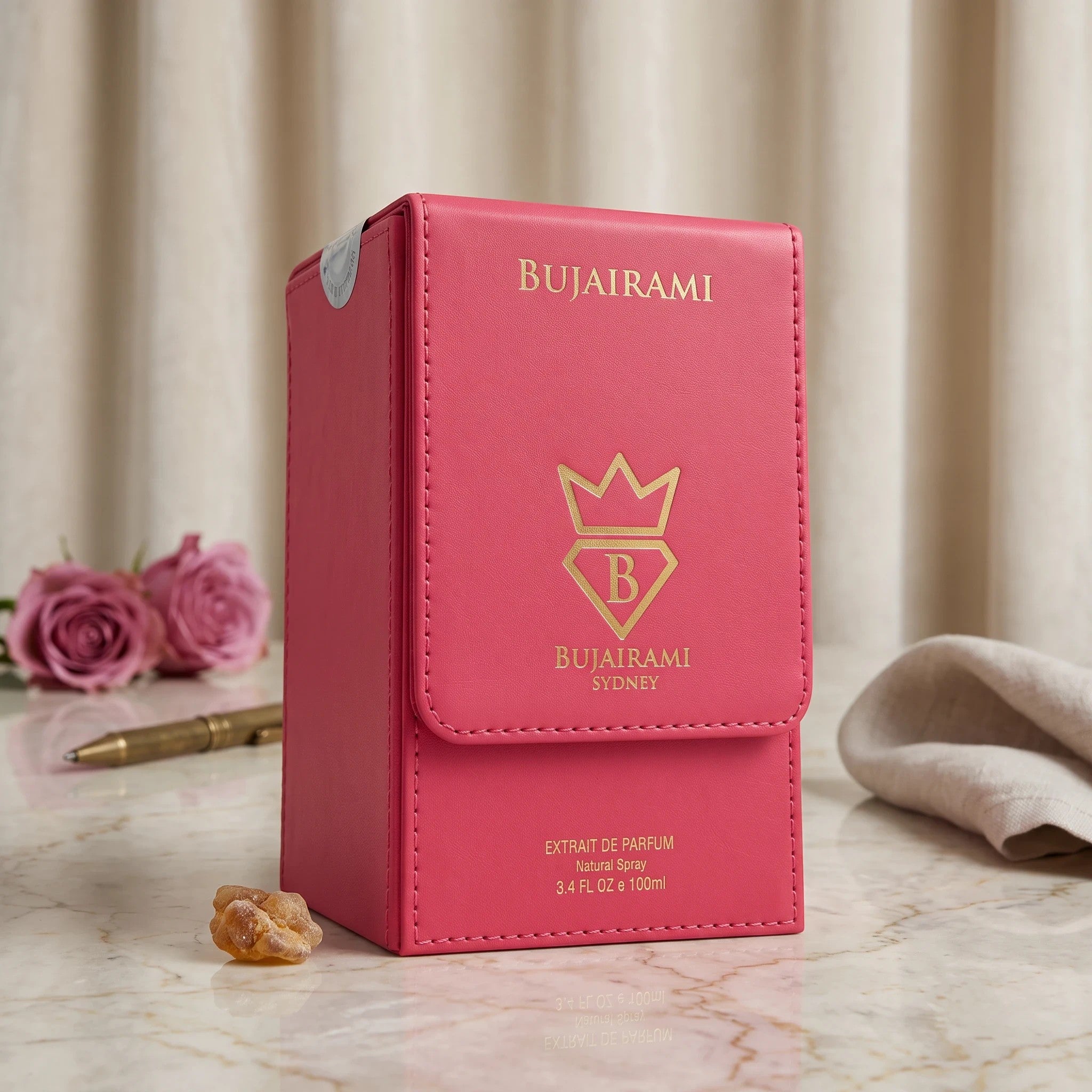 Soghaat Bujairami First Class 100ml Extrait de Parfum in a vibrant pink leather-style case with gold branding.