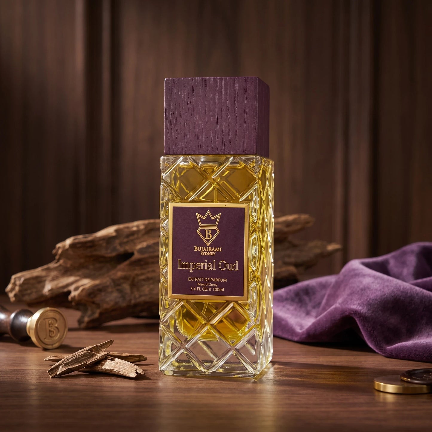 Soghaat Bujairami Imperial Oud Extrait de Parfum in a textured glass bottle with a purple wooden cap on a wood table.