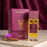 Soghaat Bujairami Imperial Oud Extrait de Parfum bottle and leather case with orchid and cinnamon on marble surface
