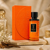Soghaat Bujairami Legacy 100ml Extrait de Parfum bottle and orange box on a marble surface with dried flowers.