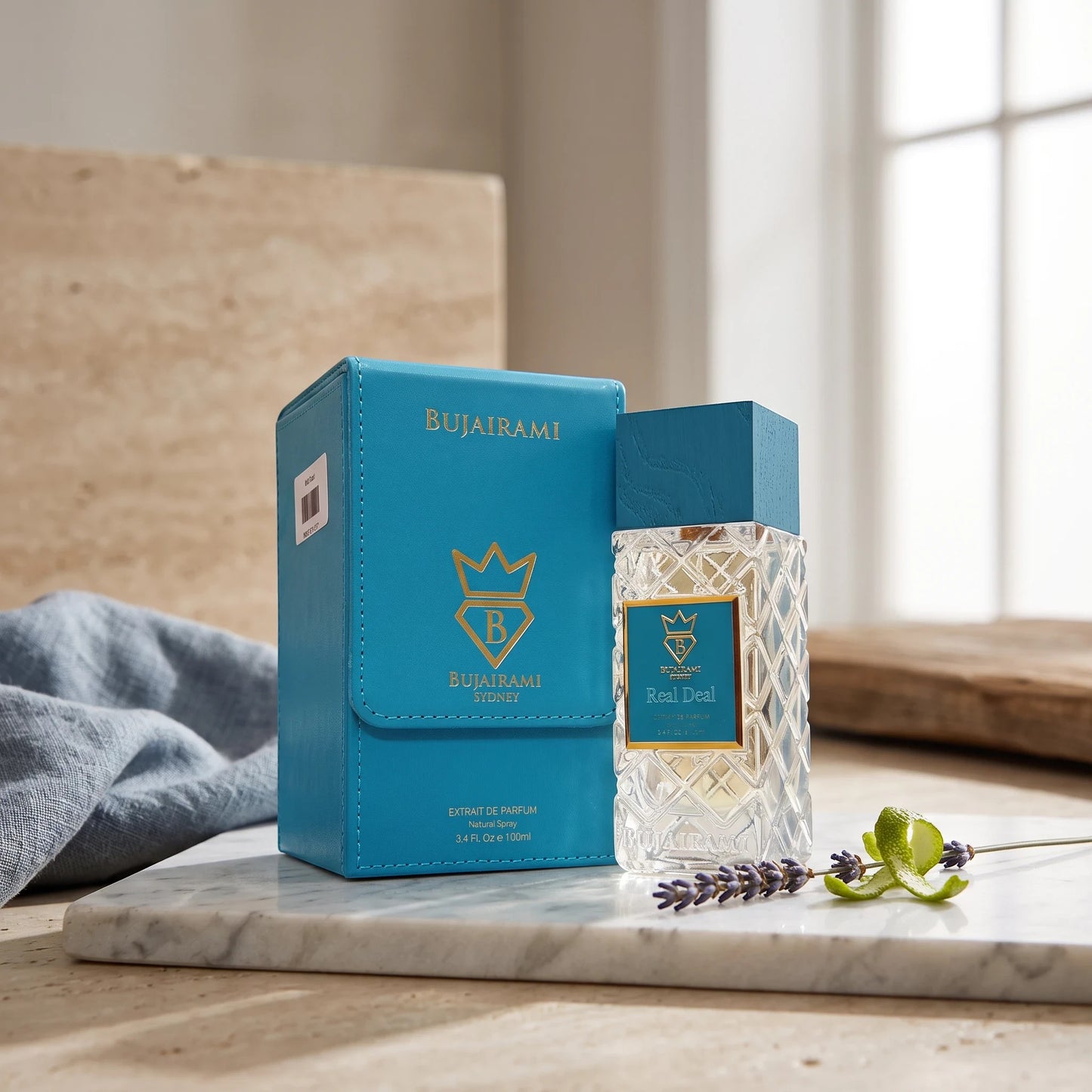 Soghaat Bujairami Real Deal unisex Extrait de Parfum bottle and blue leather case on a marble surface with lavender.