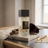 Soghaat Bujairami Shadow Script Extrait de Parfum bottle with a textured glass design and dark wood cap on marble.