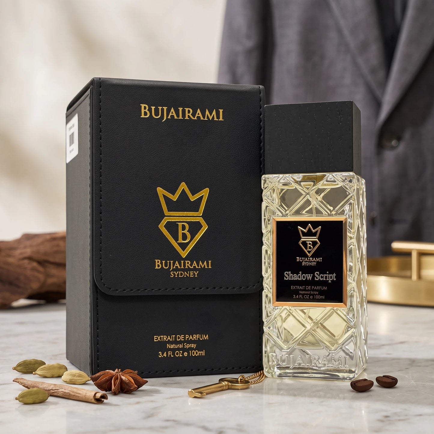 Soghaat Bujairami Shadow Script 100ml Extrait de Parfum bottle and black leather case with spices on a marble surface.