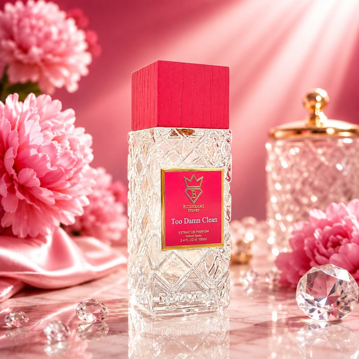 Soghaat Bujairami Too Damn Clean 100ml perfume bottle with a pink cap, set among pink flowers and crystals.