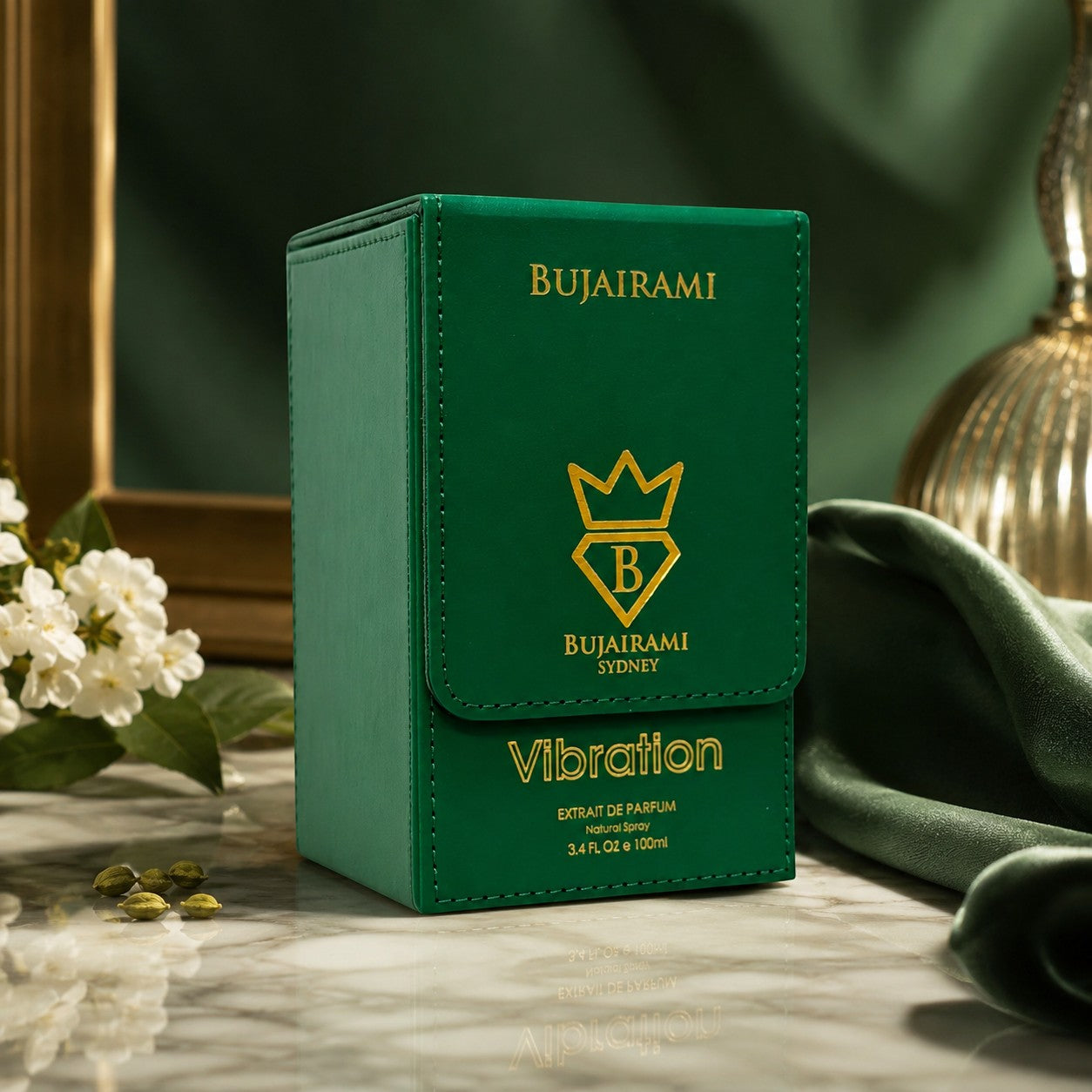 Soghaat Bujairami Vibration 100ml Extrait de Parfum in a green leather-style box on a marble surface with white flowers.