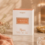 Soghaat Dumont Paris Trista Elegance 100ml Eau de Parfum box on a marble surface with soft lighting and floral decor.