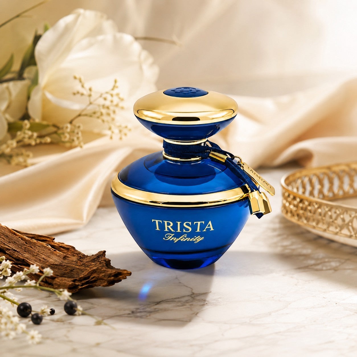 Soghaat Dumont Paris Trista Infinity Eau de Parfum in a vibrant blue glass bottle with gold accents on a marble table