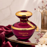 Soghaat Dumont Paris Trista Obsession Eau de Parfum in a deep purple glass bottle with gold accents on a silk cloth.