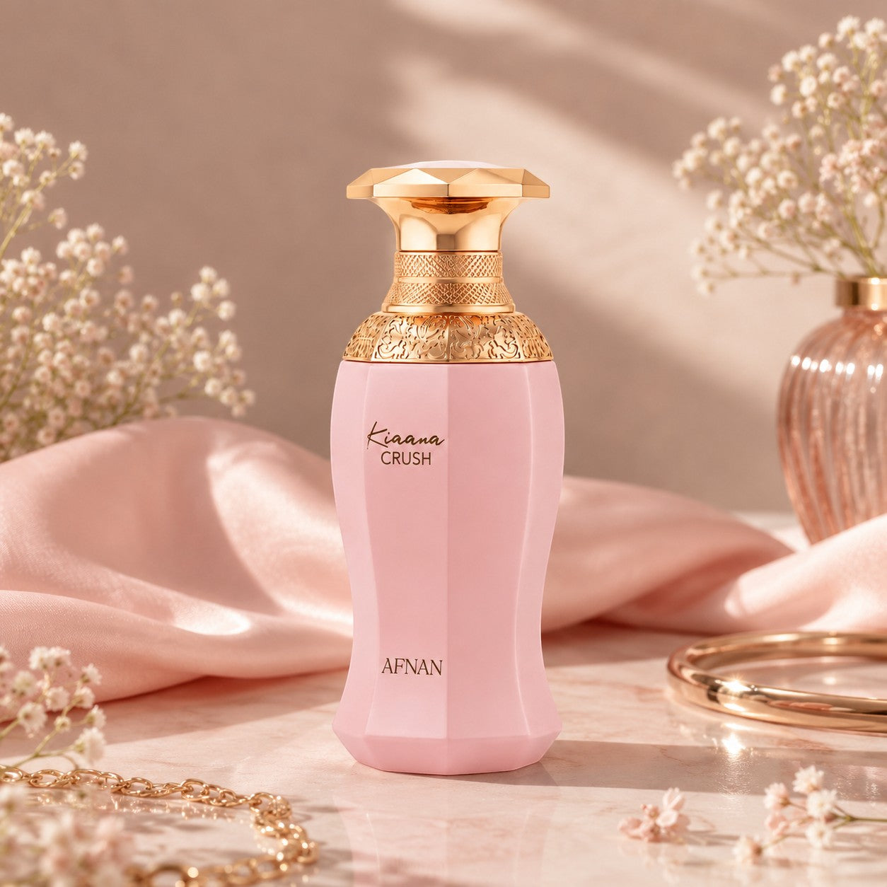 Soghaat Afnan Kiaana Crush Eau de Parfum in a pink bottle with a gold cap, set against a soft fabric background.