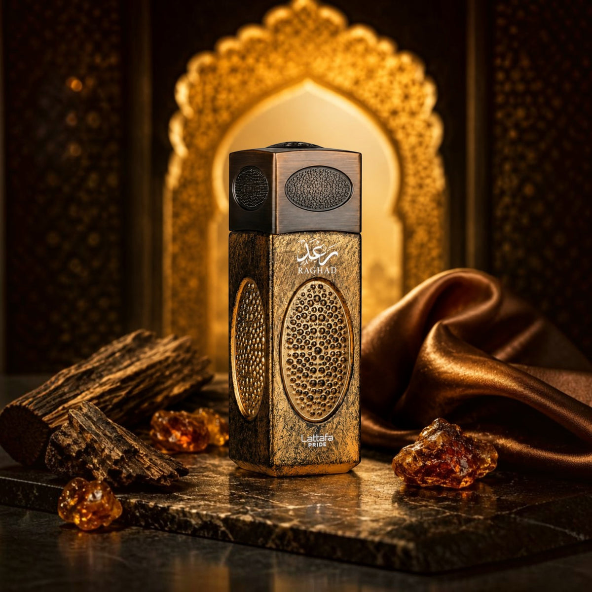 Soghaat Lattafa Pride Raghad Eau de Parfum bottle with gold textured detailing, amber resin, and wood on a dark surface.