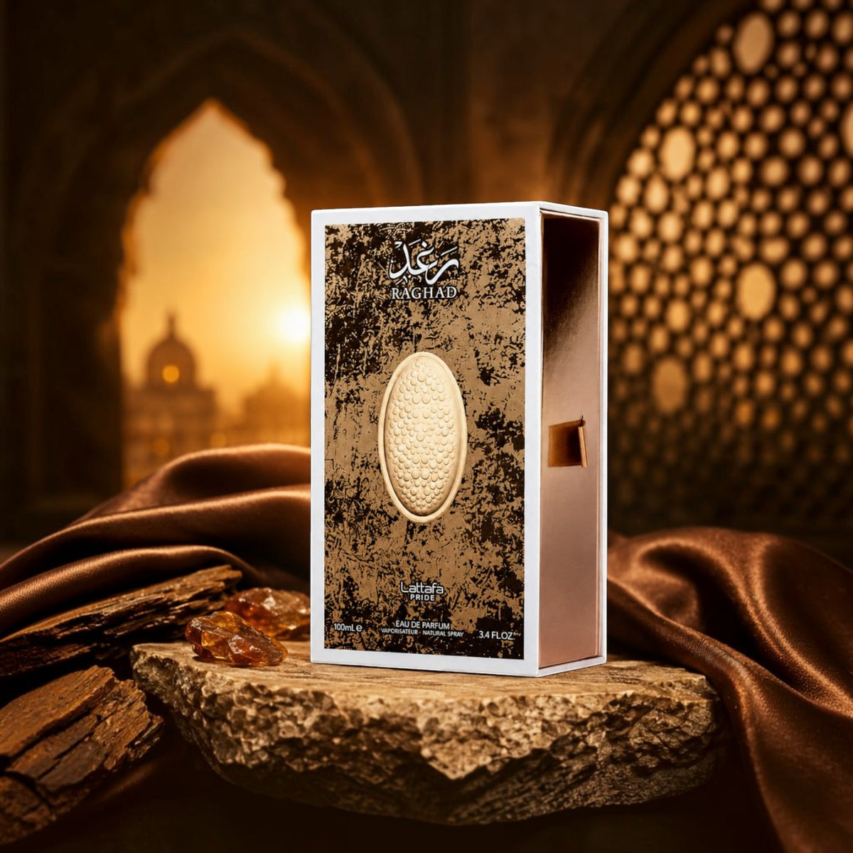 Soghaat Lattafa Pride Raghad 100ml Eau de Parfum box featuring a textured gold emblem on a stone surface at sunset.