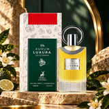 Soghaat Maison Alhambra The Aurum Luxura 100ml Eau de Parfum bottle and box on a stone surface with citrus leaves.