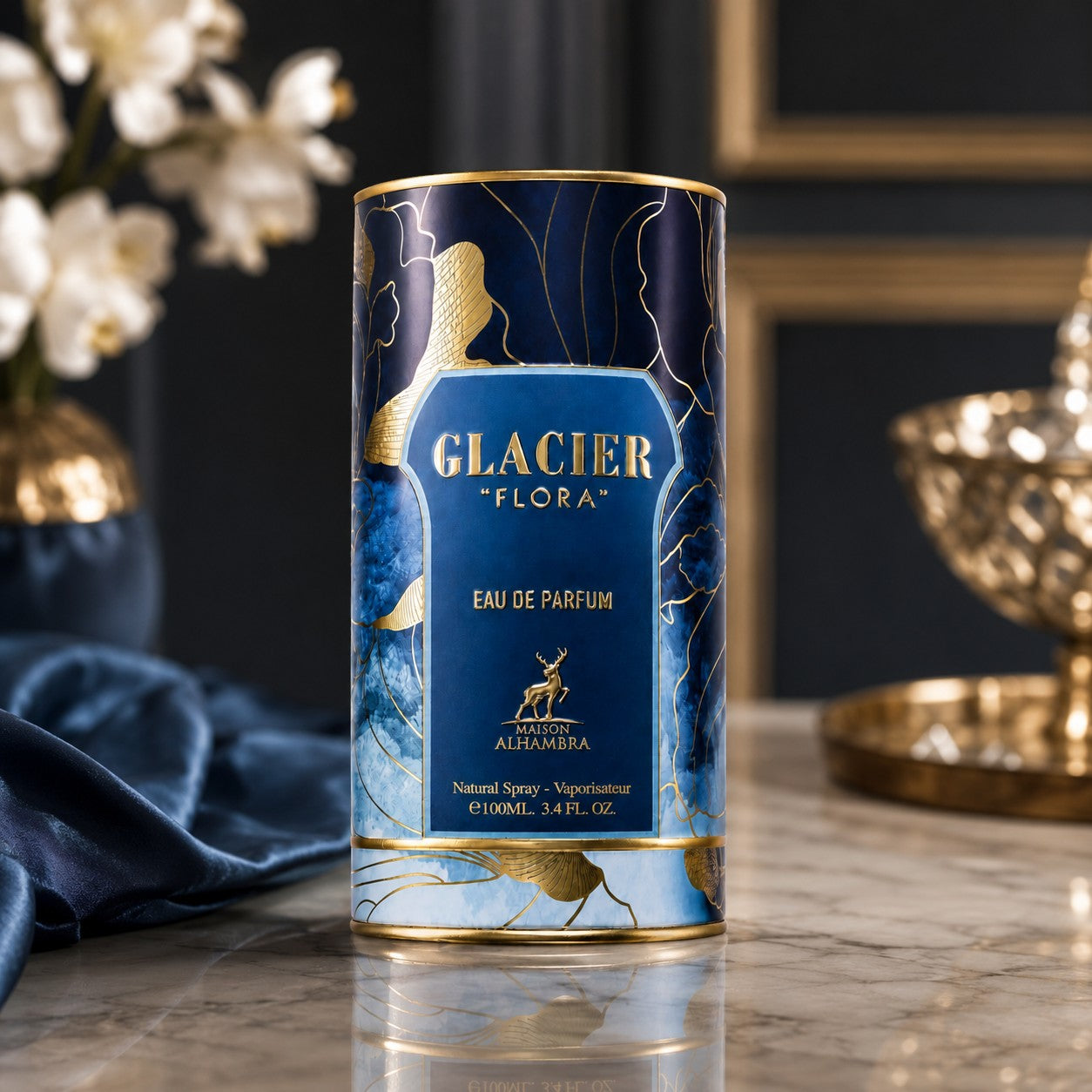 Soghaat Maison Alhambra Glacier Flora Eau de Parfum in a decorative blue and gold cylindrical bottle on a marble table.