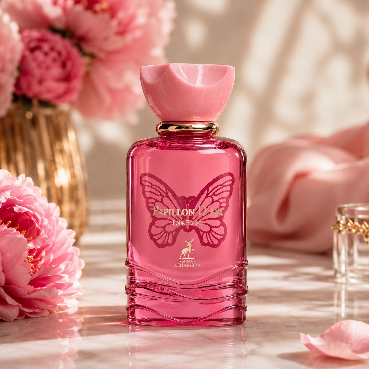Soghaat Maison Alhambra Papillon D'Or Eau de Parfum in a pink glass bottle with butterfly motif and peony flowers.