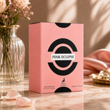 Soghaat Maison Alhambra Pink Eclipse 100ml Eau de Parfum box on a marble surface with flowers and soft lighting.