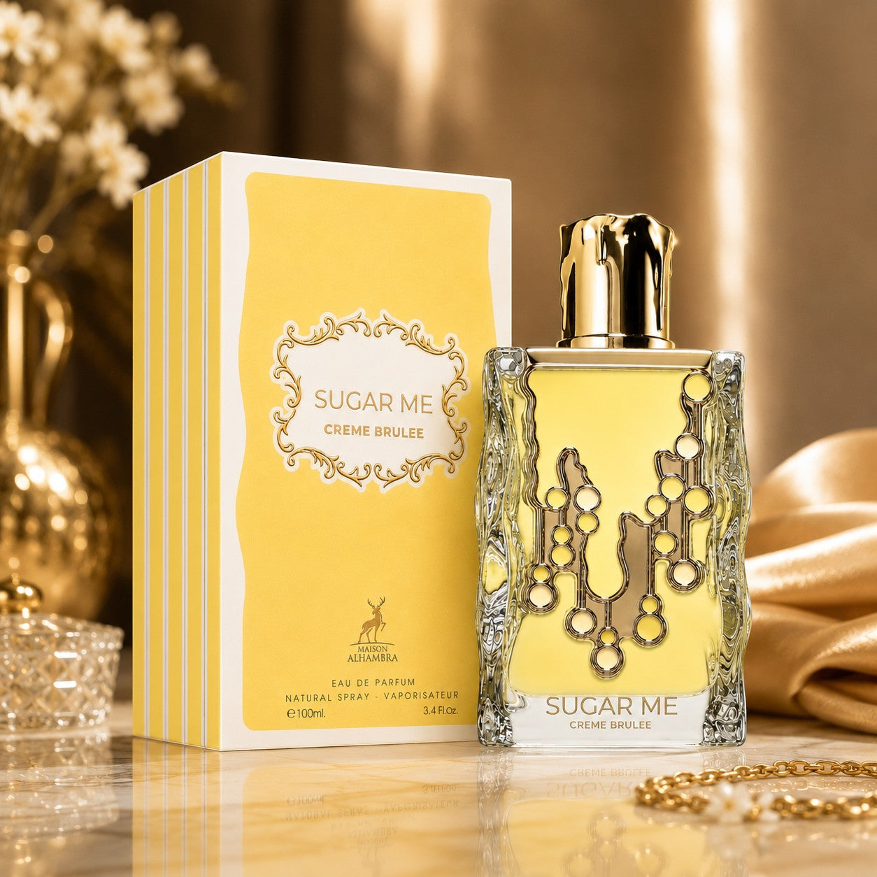 Soghaat Maison Alhambra Sugar Me Creme Brulee 100ml Eau de Parfum bottle and yellow box on a gold surface.