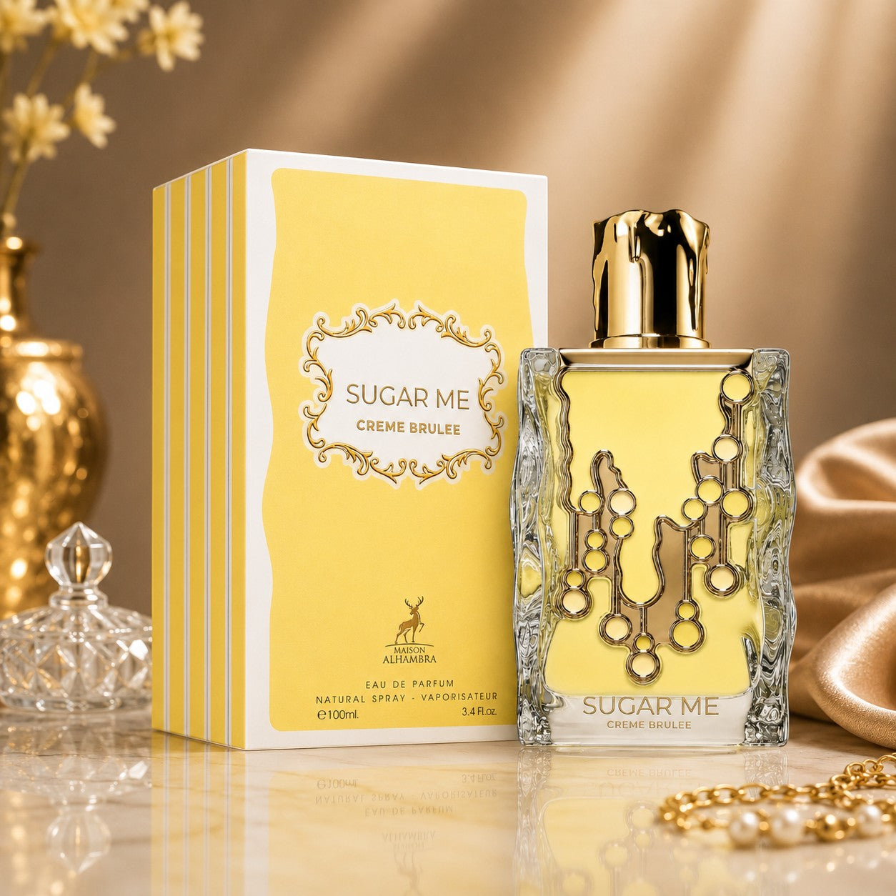 Soghaat Maison Alhambra Sugar Me Creme Brulee Eau de Parfum bottle and yellow box on a marble surface.