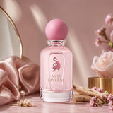 Soghaat Miss Laverne Eau de Parfum in a pink glass bottle with a round cap, surrounded by roses and silk fabric.