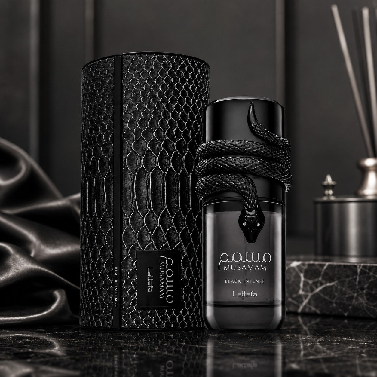 Soghaat Lattafa Musamam Black Intense Eau de Parfum bottle with a snake design next to its textured black case.
