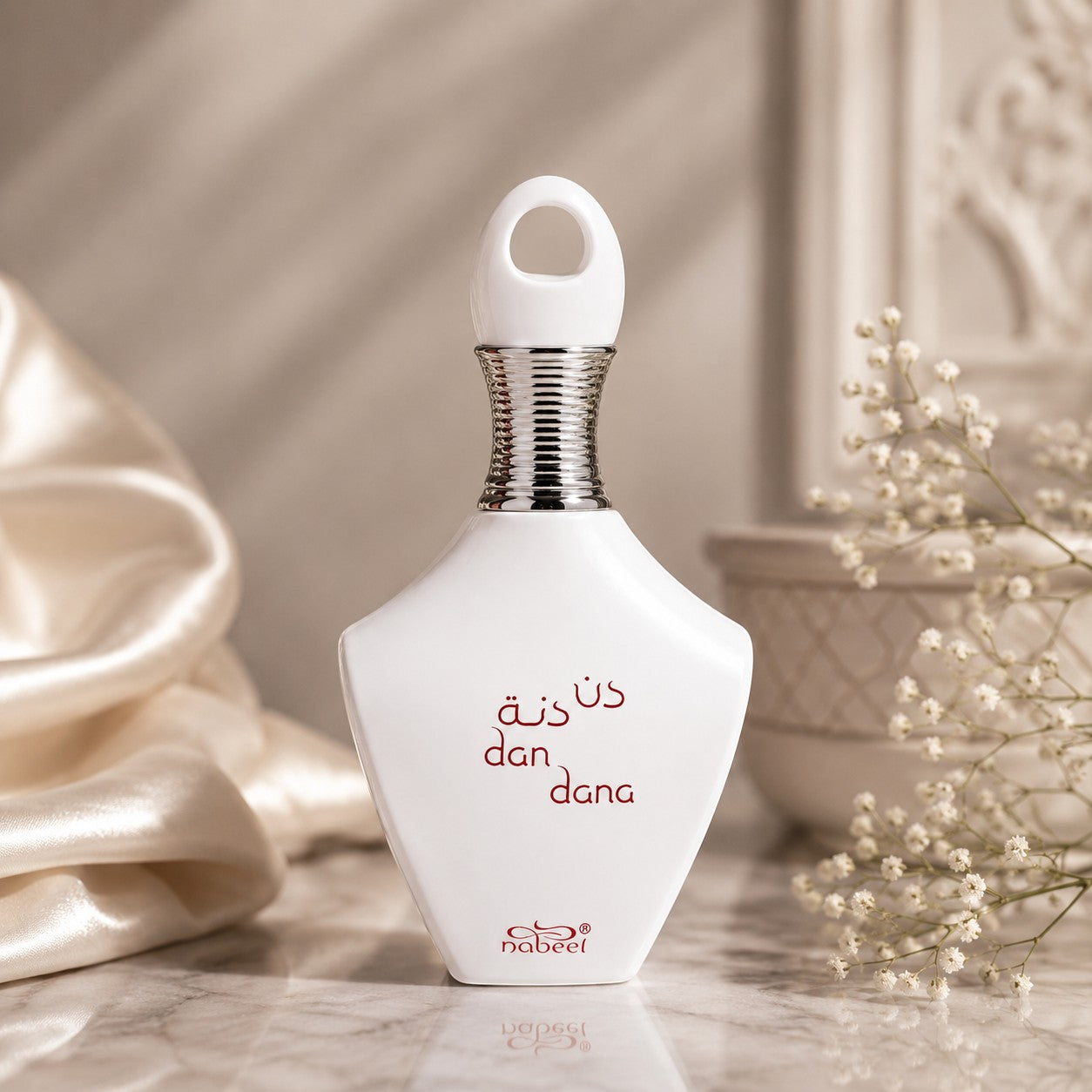 Soghaat Nabeel Dan Dana Eau de Parfum in a white, teardrop-shaped bottle with a silver neck, set on a marble surface.