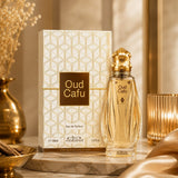 Soghaat Nabeel Oud Cafu 100ml Eau de Parfum bottle and patterned box on a marble surface with gold accents