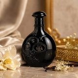 Soghaat Nyla Suede Eau de Parfum in a sleek black round bottle with gold lettering, styled with vanilla and flowers.