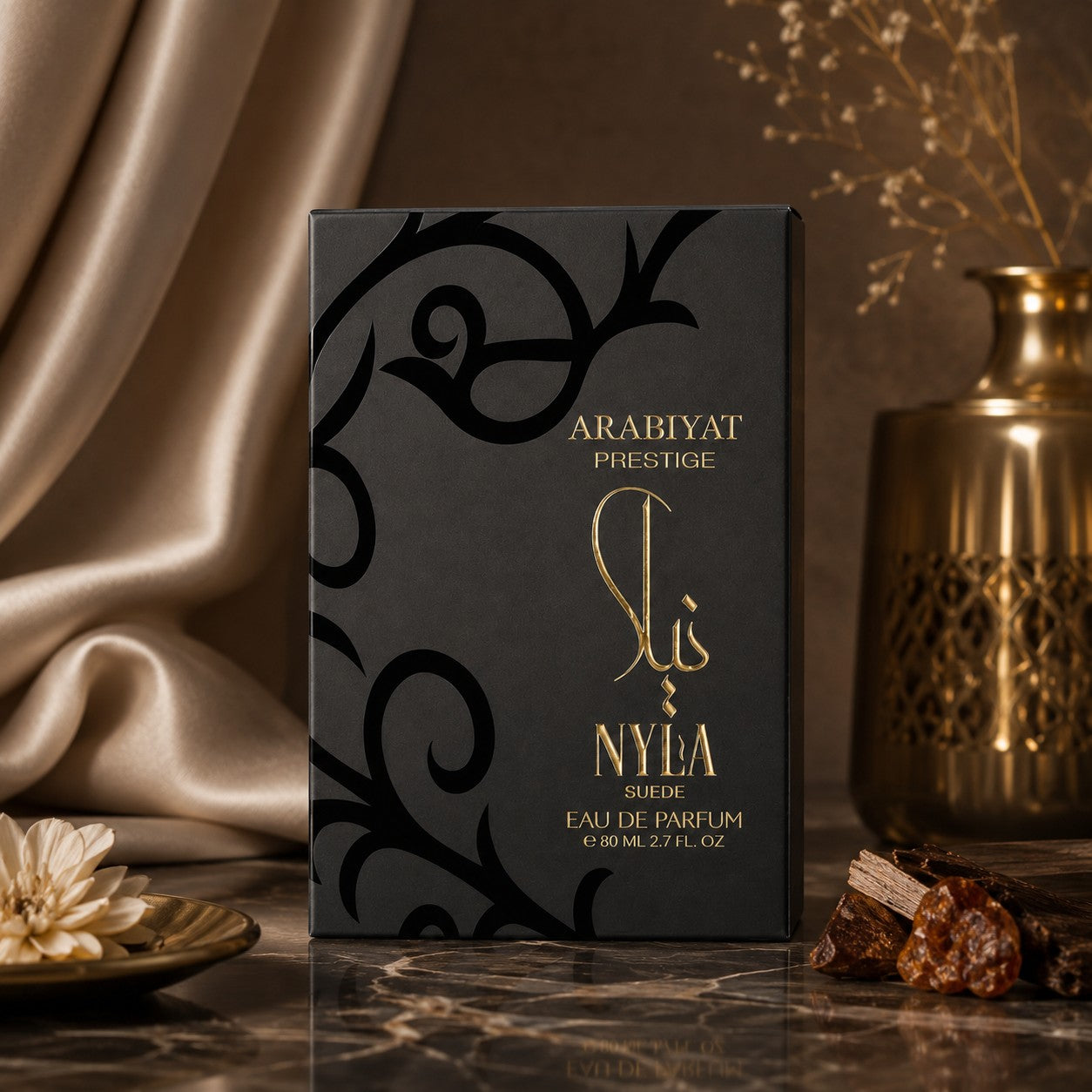 Soghaat Nyla Suede Eau de Parfum by Arabiyat Prestige in a black box with gold calligraphy on a marble surface.