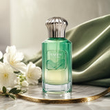 Soghaat Opaline Wave Extrait de Parfum bottle with green glass, silver cap, and white flowers on a marble surface.