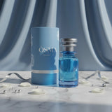 Soghaat Osma Amber’ S Eau de Parfum bottle and cylindrical box, blue with white floral accents. Sweet amber gourmand fragrance.