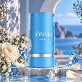 Soghaat Osma Ambry A 75ml Eau de Parfum in a blue cylindrical bottle with rose motifs, set against a coastal backdrop.