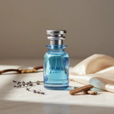 Soghaat Osma Woody S Eau de Parfum, a blue glass bottle with silver cap, featuring floral etching and blue liquid.