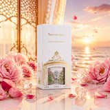 Soghaat Princess Reef Eau de Parfum bottle in a white box with gold detailing, surrounded by pink flowers at sunset.