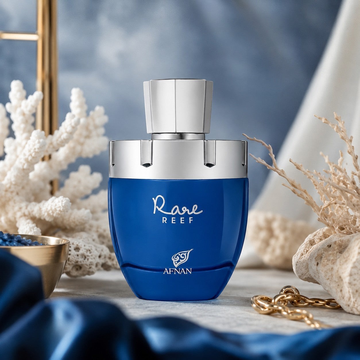 Soghaat Rare Reef by Afnan unisex Extrait de Parfum in a vibrant blue bottle with silver cap, set against coral decor.