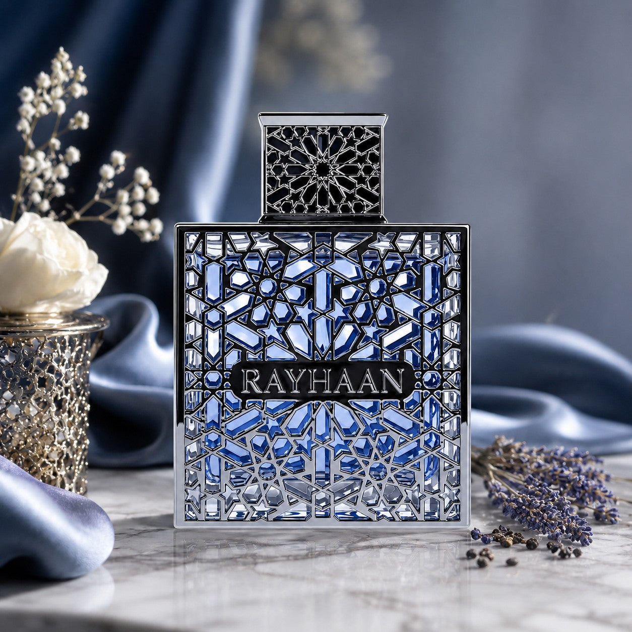 Soghaat Rayhaan Aquatica Eau de Parfum in a blue glass bottle with an intricate silver geometric lattice overlay.