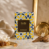Soghaat Rayhaan Seville Eau de Parfum 100ml bottle with a yellow and geometric pattern. Fresh woody aromatic scent.