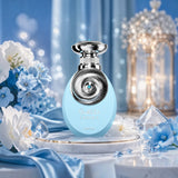 Soghaat Riiffs Tahira Extrait de Parfum in a light blue bottle with a silver spiral cap, surrounded by blue flowers.