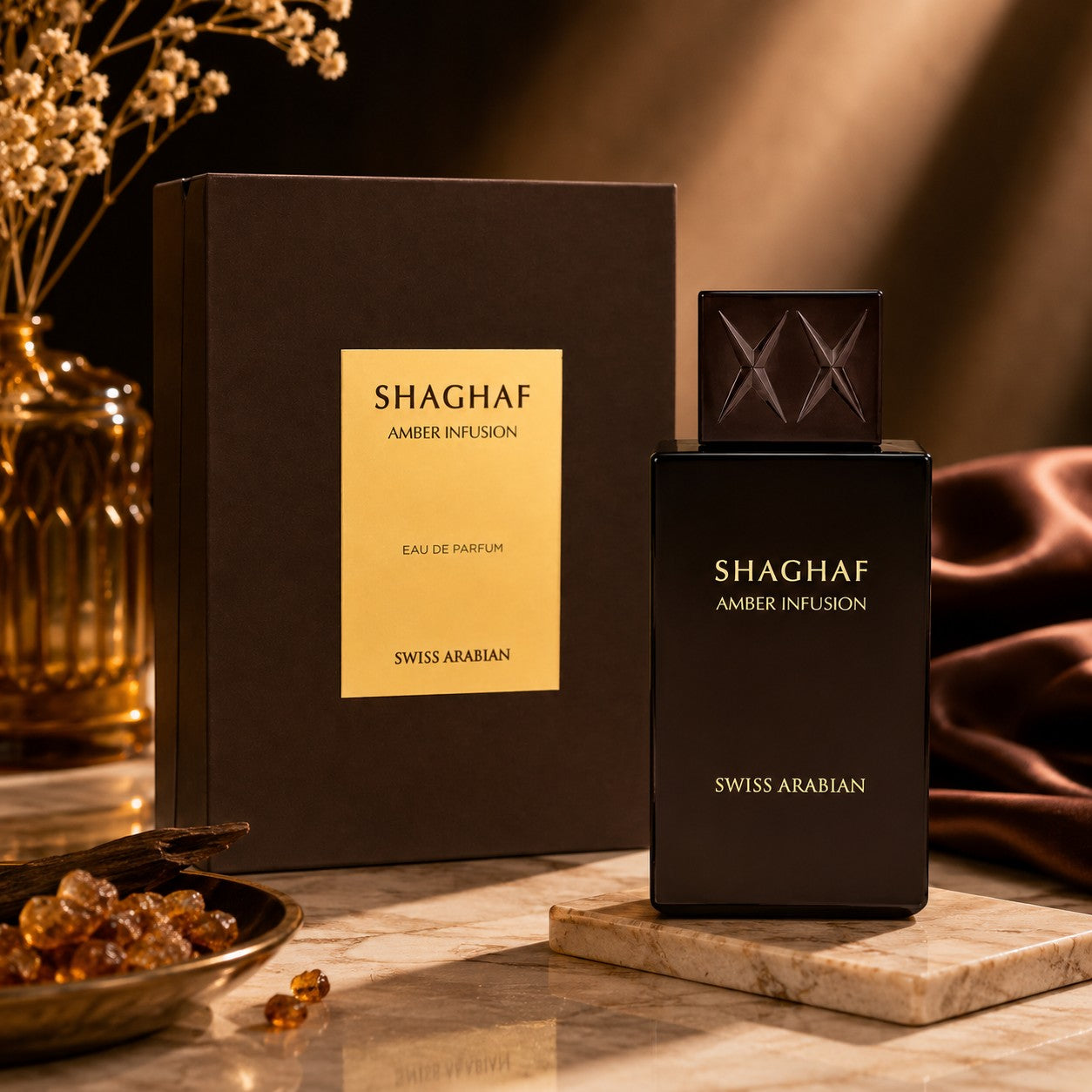 Soghaat Swiss Arabian Shaghaf Amber Infusion Eau de Parfum bottle and box on a marble surface with amber resin.