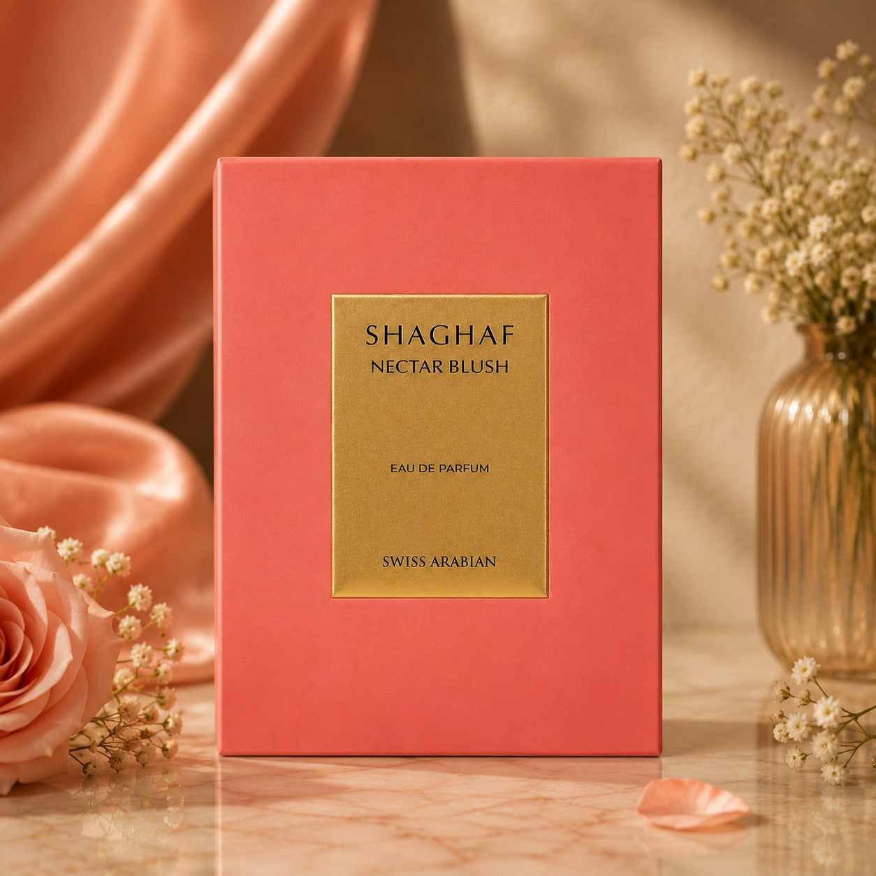 Soghaat Shaghaf Nectar Blush Eau de Parfum by Swiss Arabian in a coral pink box with a gold label on a marble table.