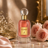Soghaat Maison Alhambra So Candid Eau de Parfum in a glass bottle with pink liquid, surrounded by roses and pearls.