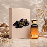Soghaat Ahmed Al Maghribi Summer Oud Eau de Parfum bottle and box with gold cap on a marble surface with dried flowers.