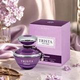 Soghaat Dumont Paris Trista Queen Eau de Parfum bottle and purple box on a marble table with flowers.